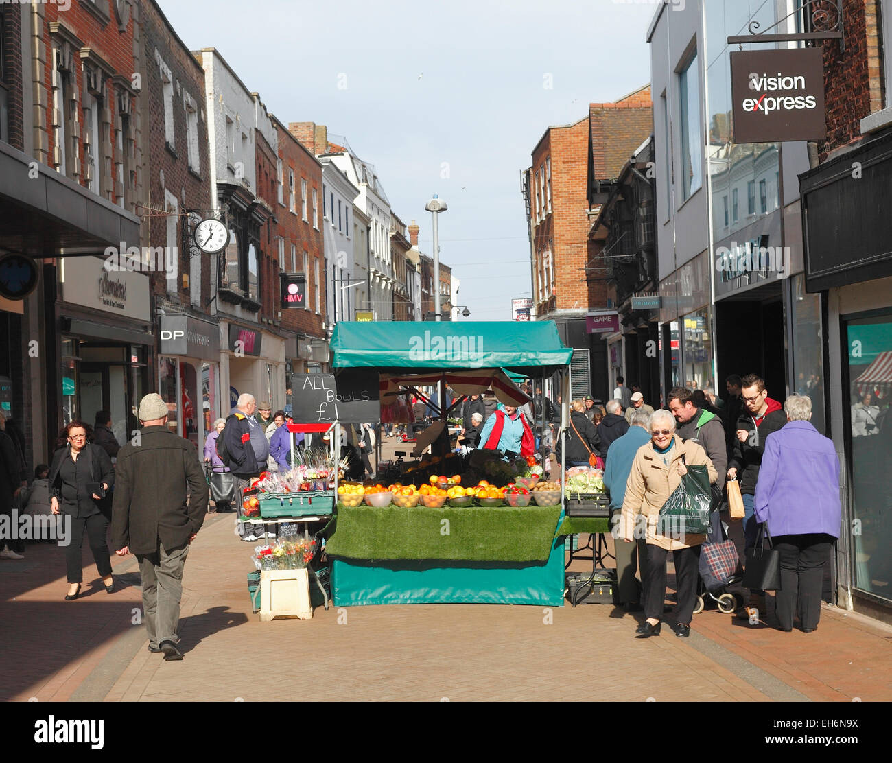 High street shopping in King's Lynn, Norfolk with a fruit and veg market stall. Stock Photo