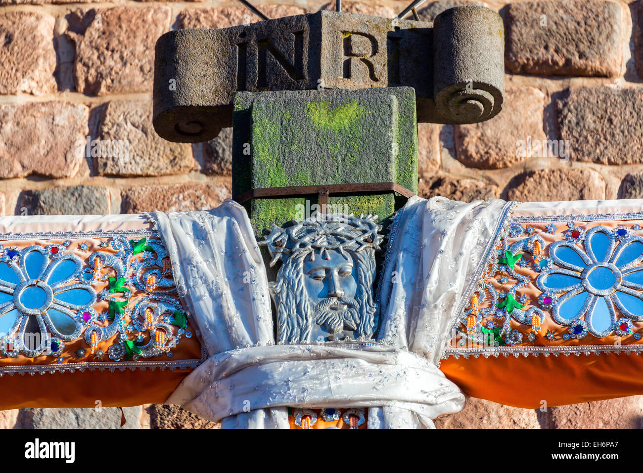 Closeup of a cross with an engraving of Jesus in Cusco, Peru Stock Photo