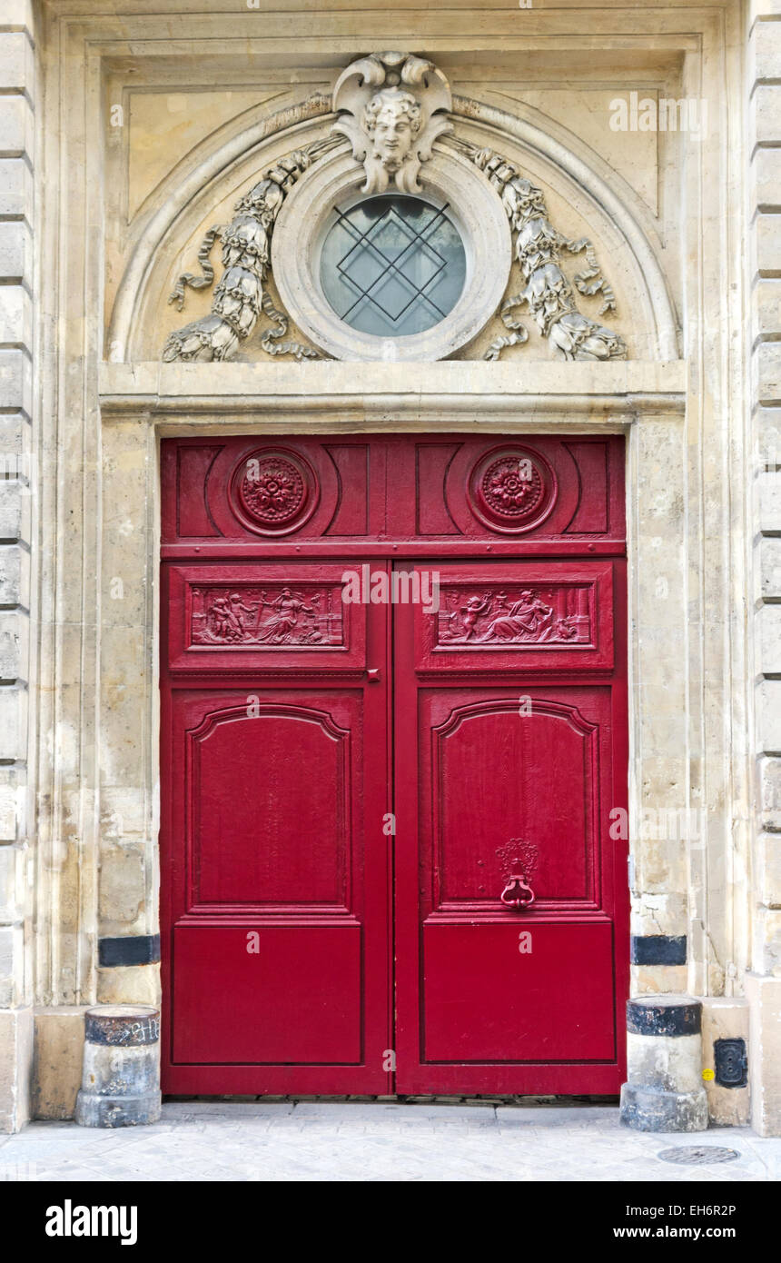 The elaborately carved, bright red doors of the Hôtel de Villeflix, Rue des Archives, Paris. Stock Photo