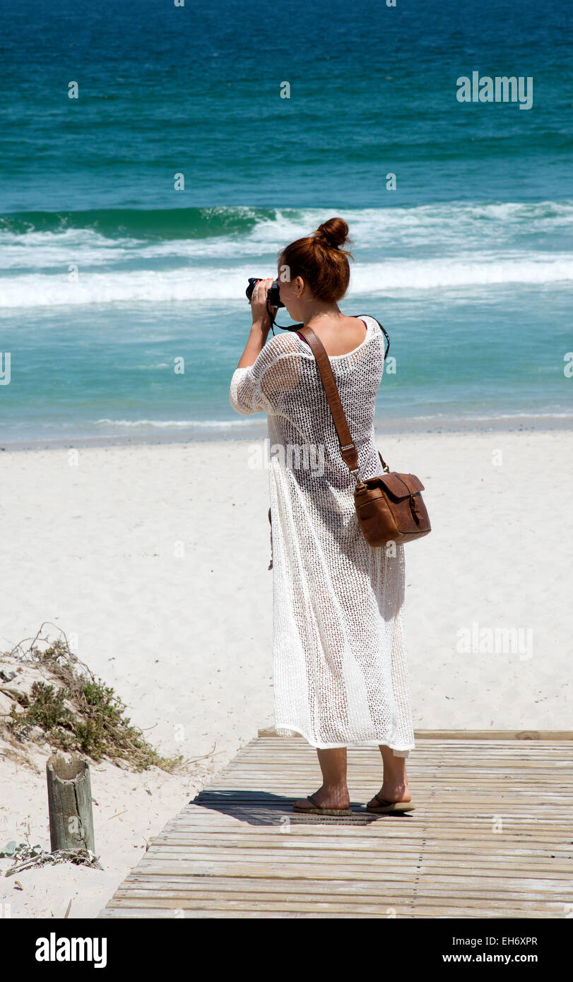 Holidaymaker taking a photo near the sea  Sunrise Beach Cape Town South Africa Stock Photo