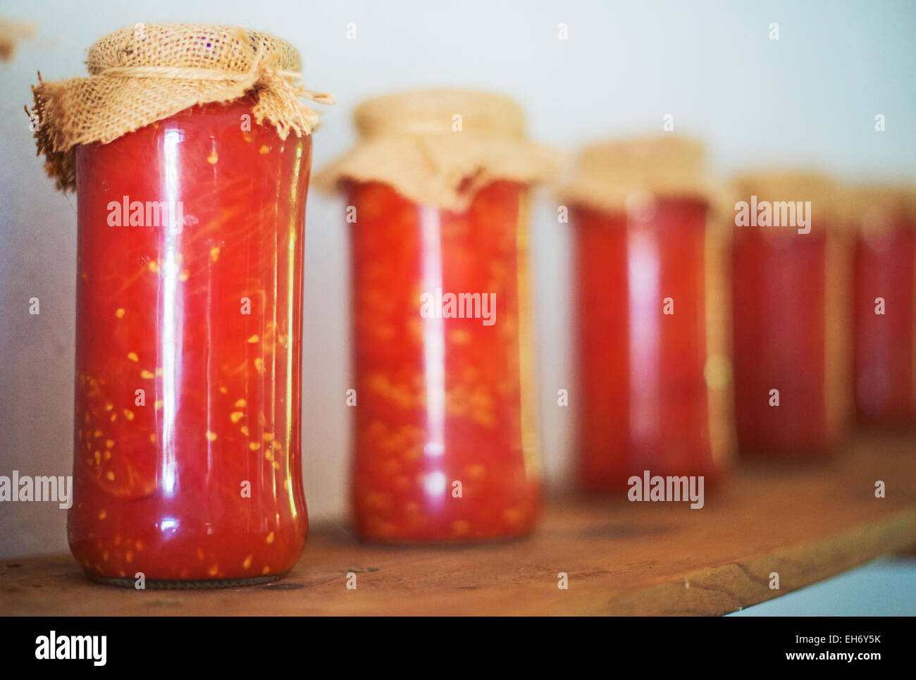 Canned tomatoes in glass jars on wooden shelf Stock Photo Alamy
