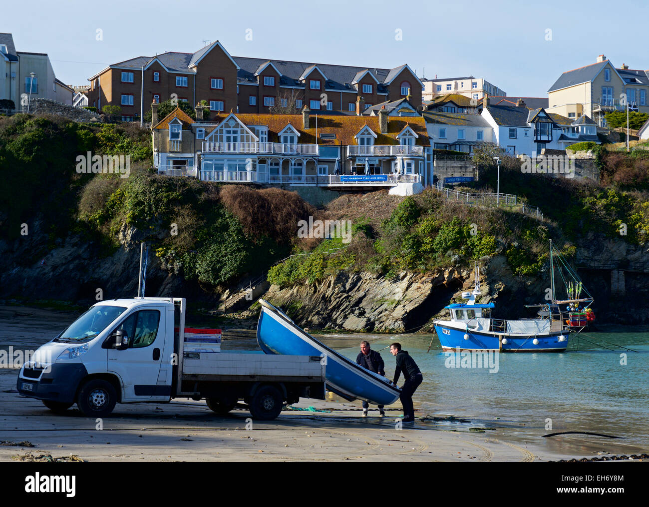 Two men manhanding a dinghy from the back of small lorry, Newquay, Cornwall, England UK Stock Photo
