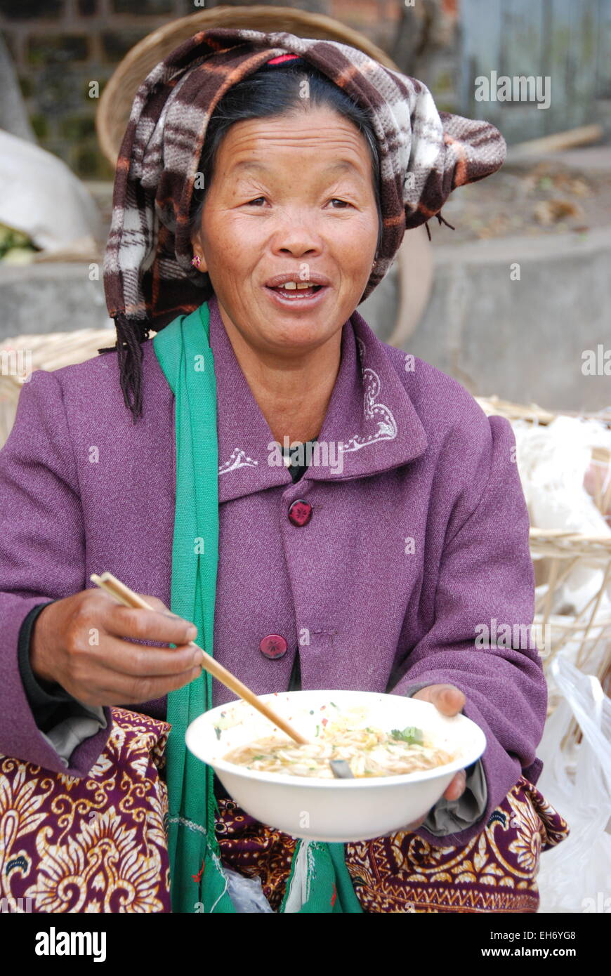 Woman eating in bowl with chopsticks, Kengtung Market Stock Photo