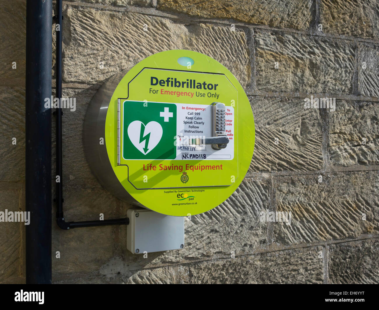 Wall mounted heart defibrillator life saving equipment for cardiac arrest with code lock for public use. England UK Stock Photo