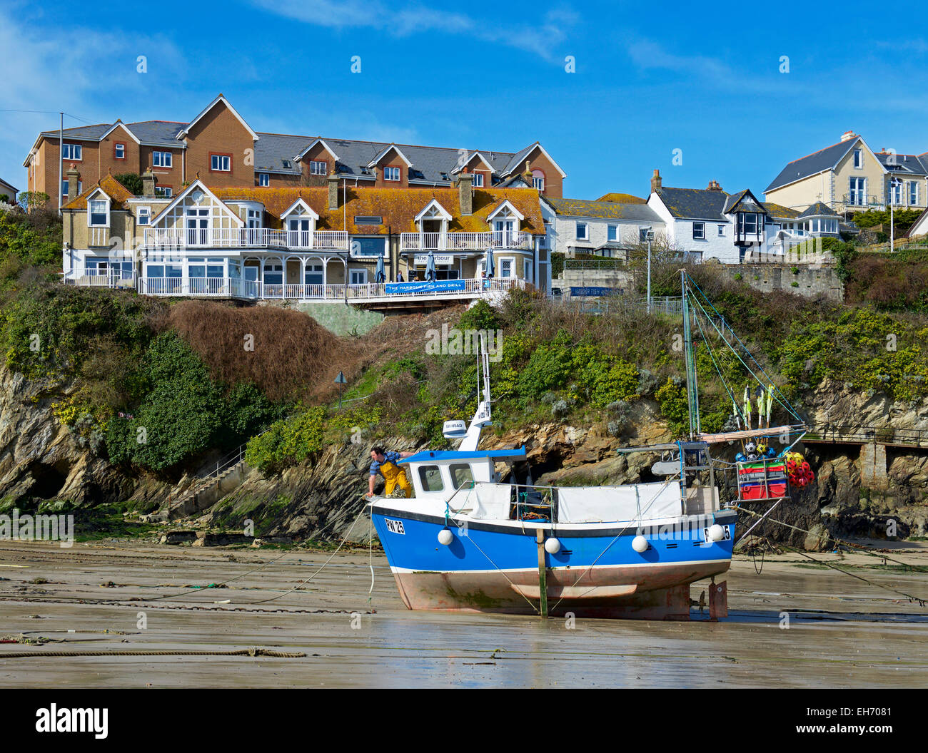 Man on fishing boat, the harbour at low tide, Newquay, Cornwall, England UK Stock Photo