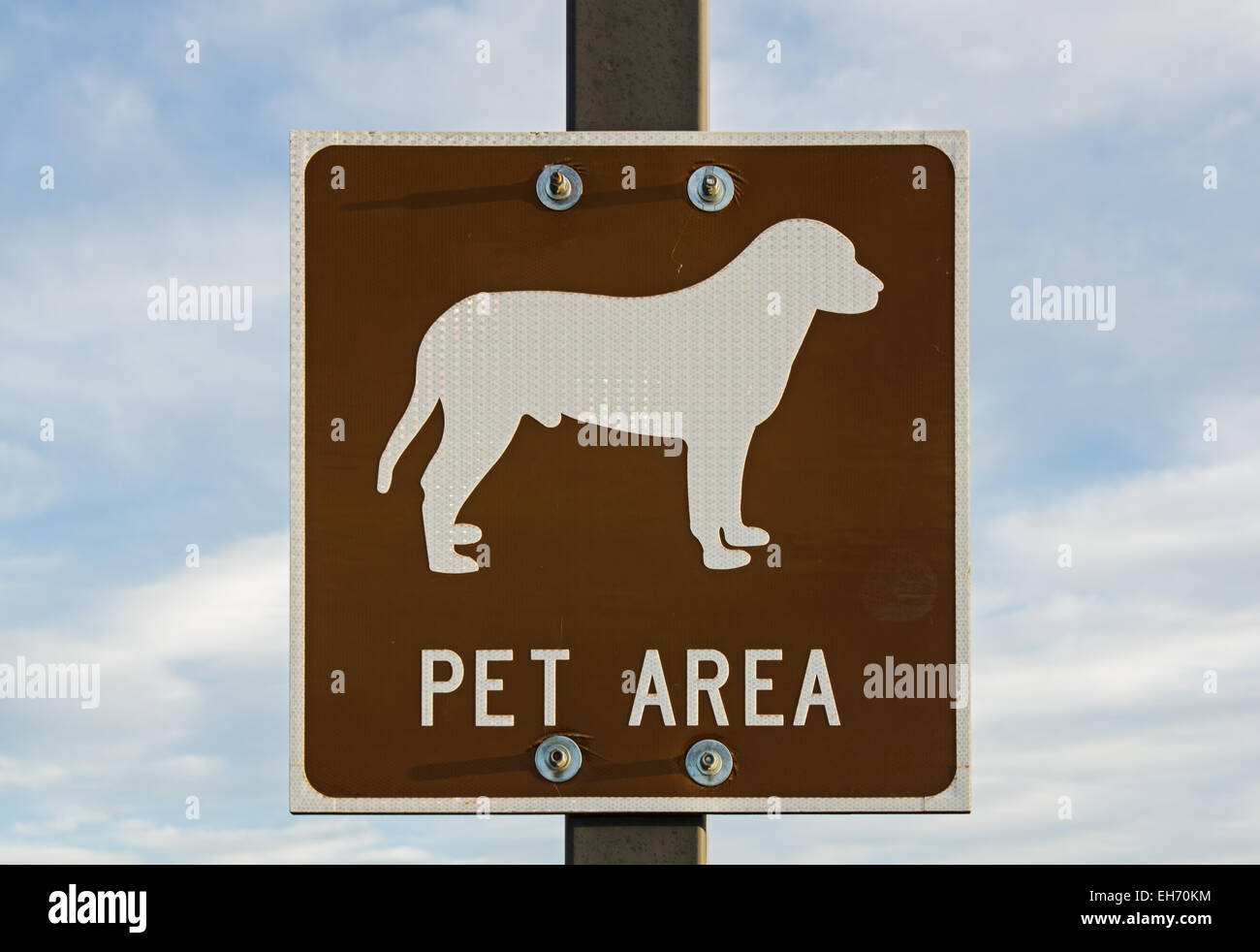brown and white pet area sign with mostly cloudy sky background Stock Photo