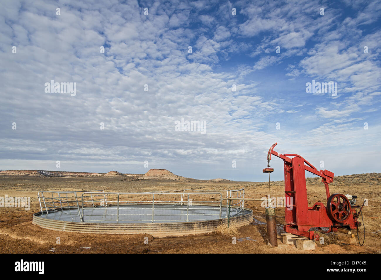 water well and pump filling a frozen over stock tank Stock Photo