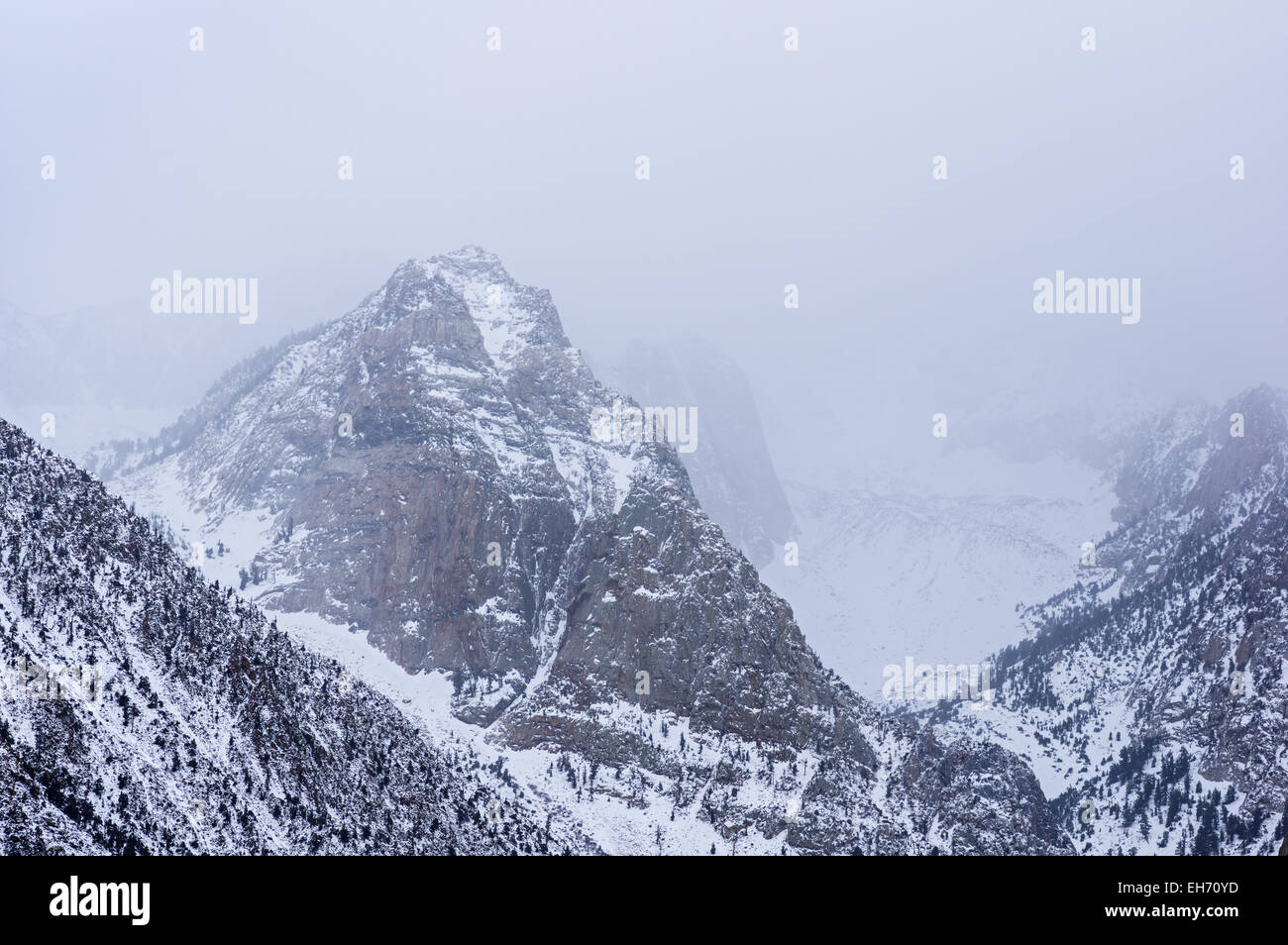 snowy mountains with peaks fading into the clouds Stock Photo