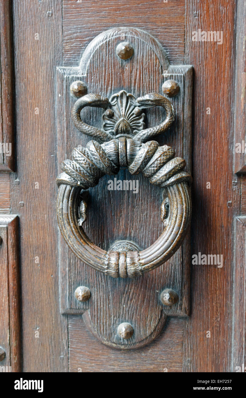 Two serpents twine around a knocker on the door of the Hôtel Sully in the Marais district of Paris. Stock Photo