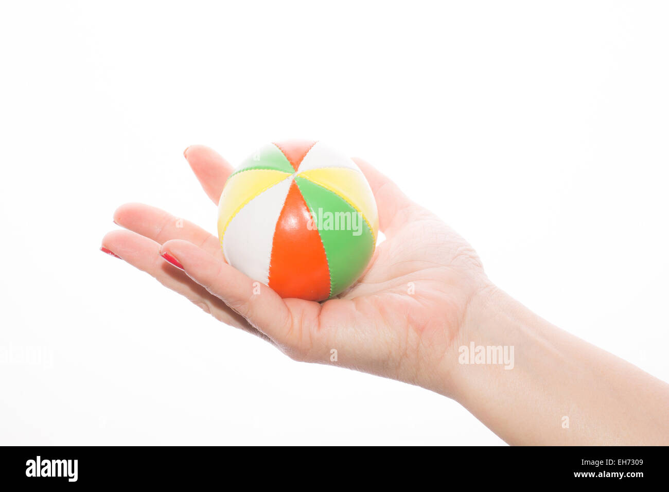 female hand holding colored juggling balls on a white background Stock