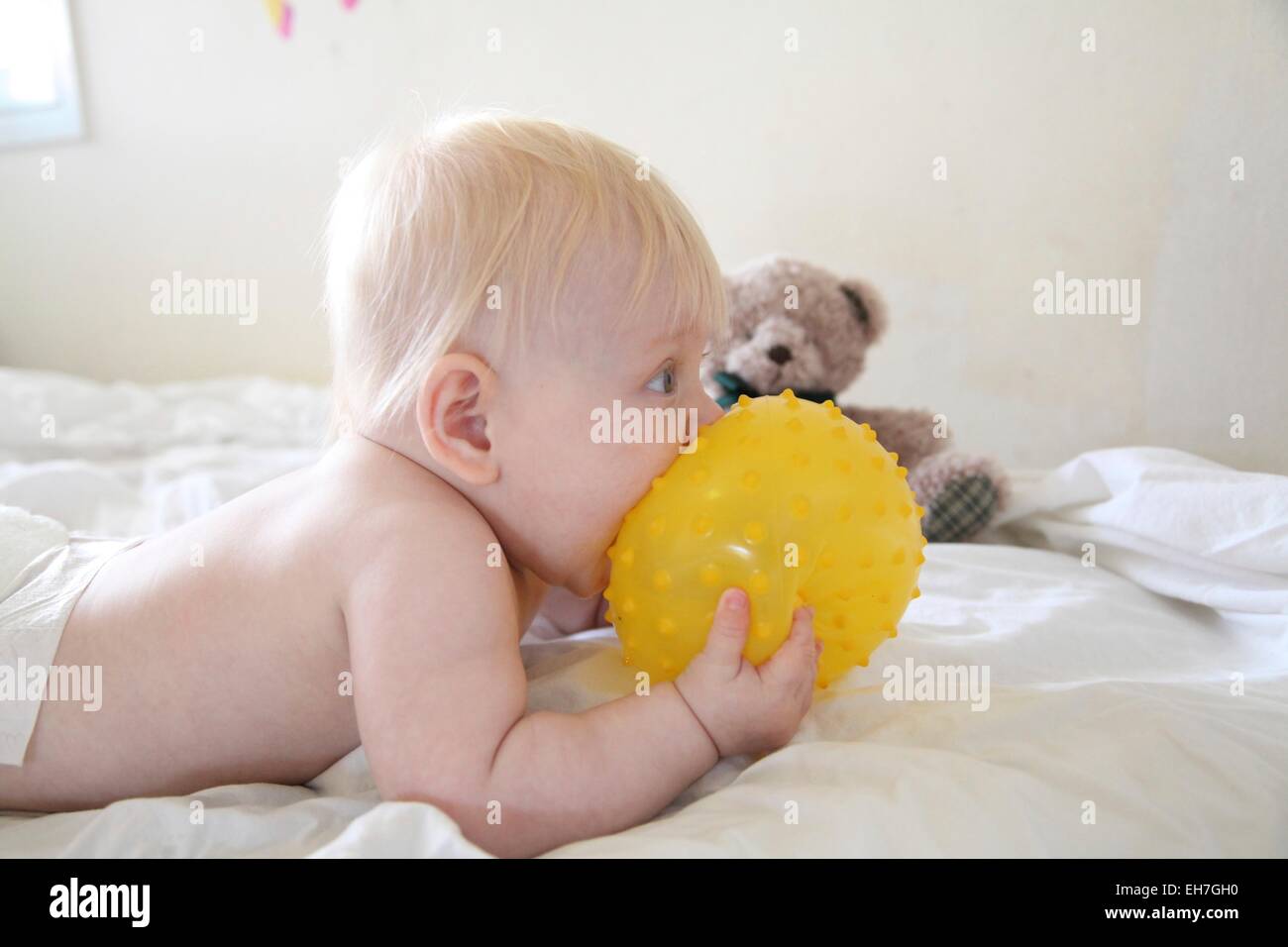 baby eats a yellow ball. Stock Photo