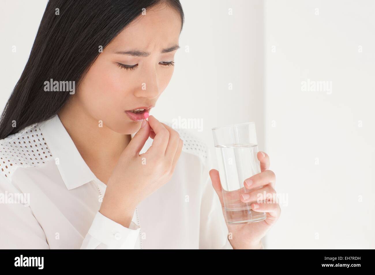 Woman taking painkiller Stock Photo