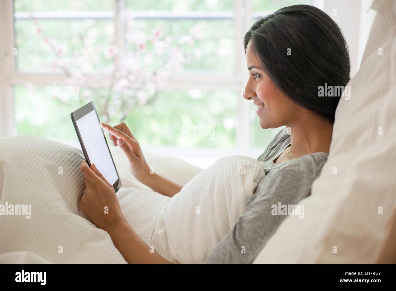 Woman in bed using digital tablet Stock Photo