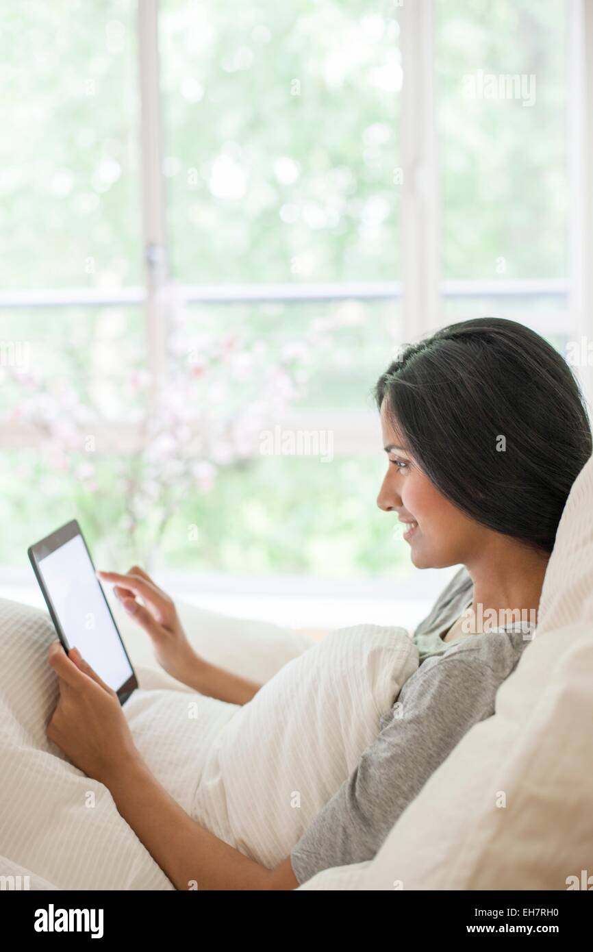 Woman in bed using digital tablet Stock Photo