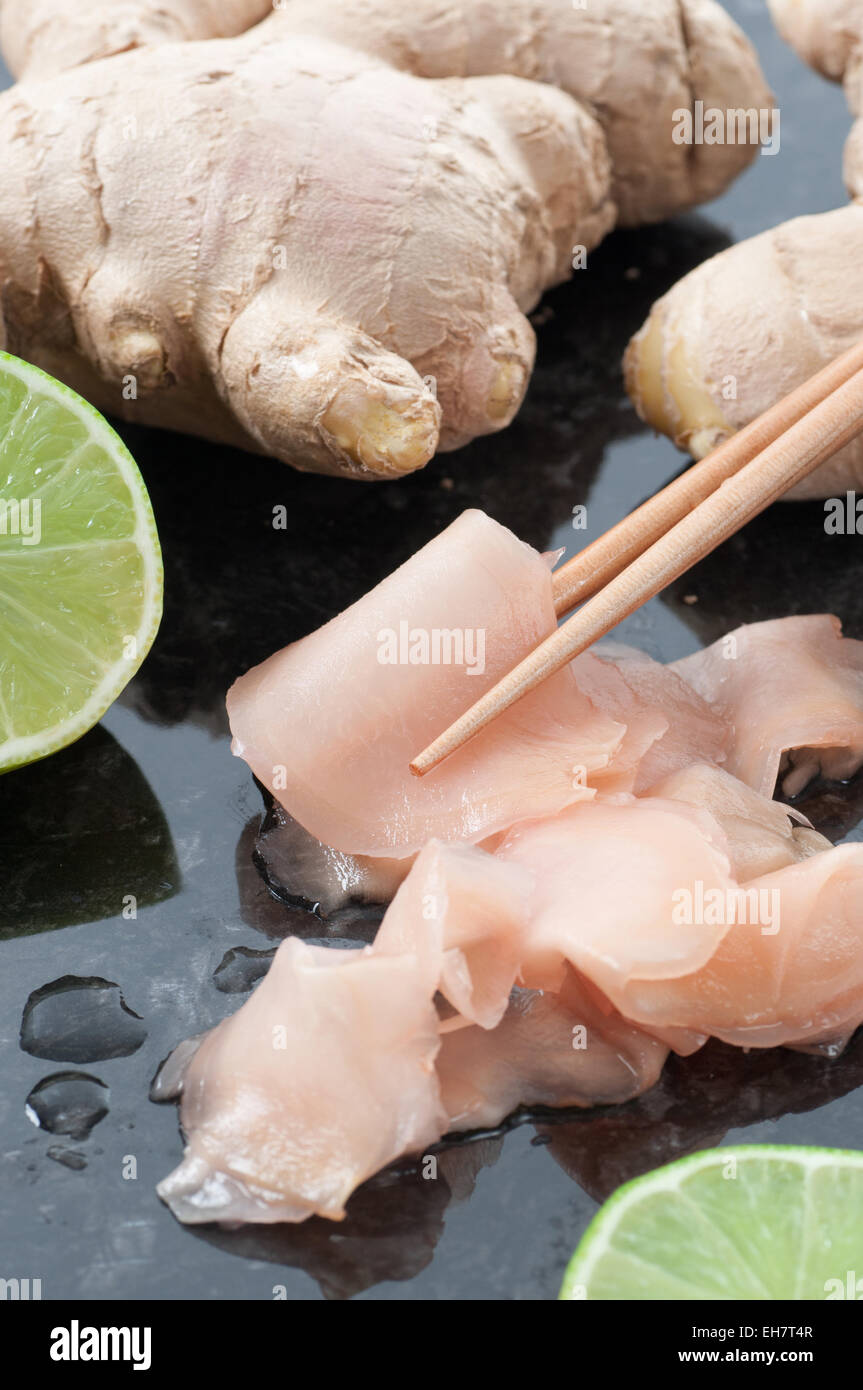 Marinated sliced ginger, fresh ginger, chopsticks and lime. Stock Photo