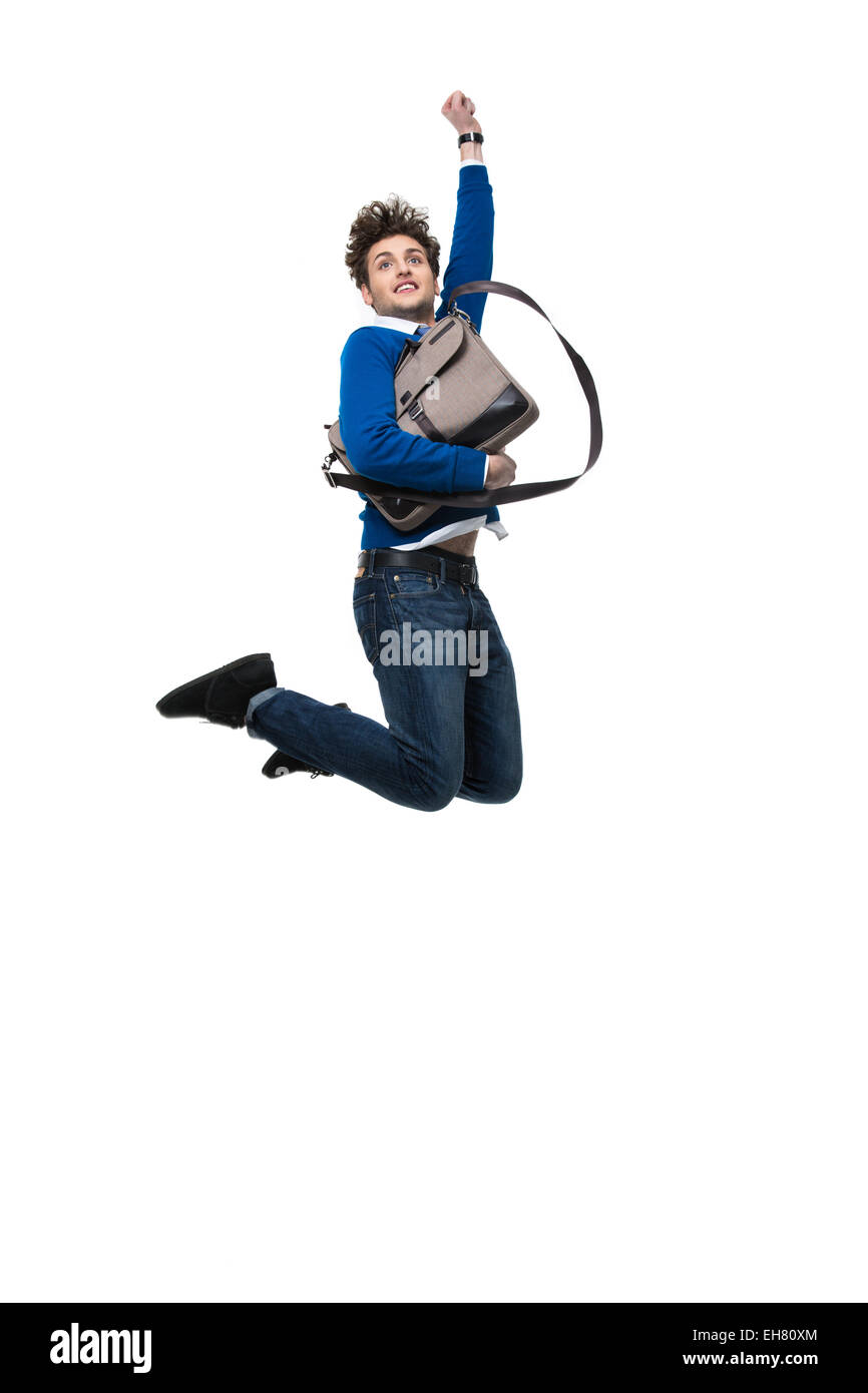 Smiling business man jumping with bag over white background Stock Photo