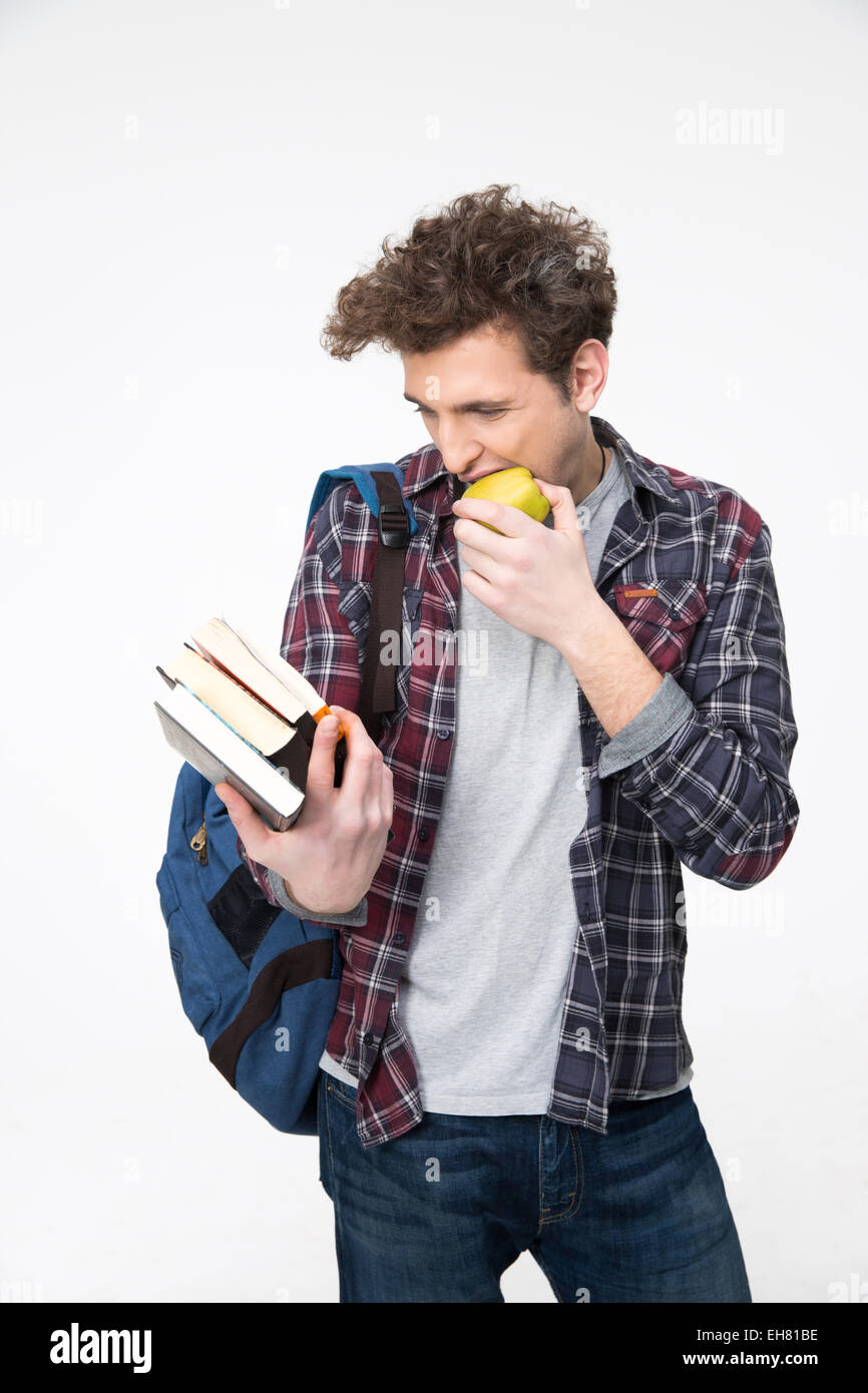 Happy young man looking at the book and biting apple Stock Photo