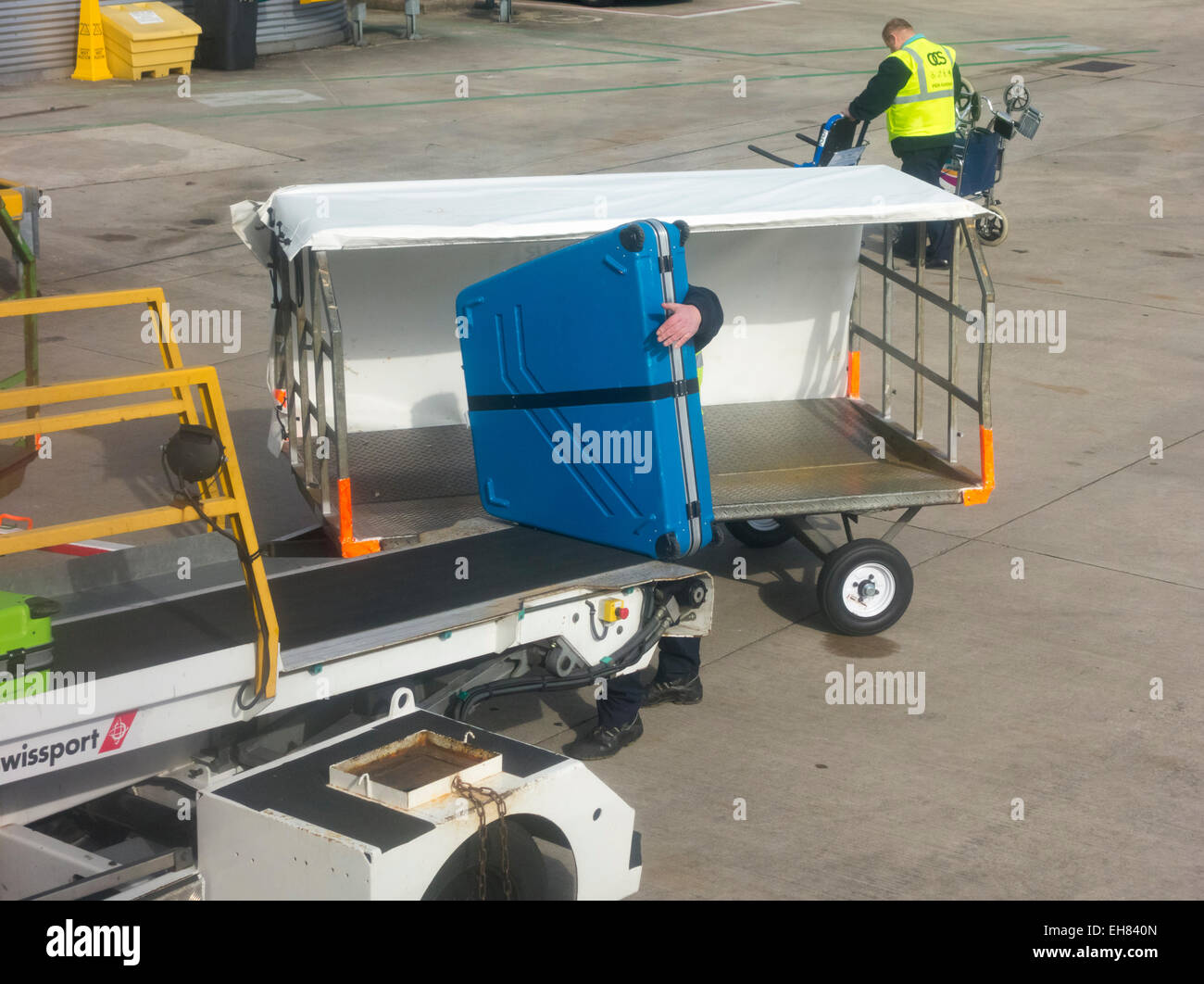 Swissport baggage handler loading bike onto Ryanair flight at Manchester UK Stock Photo