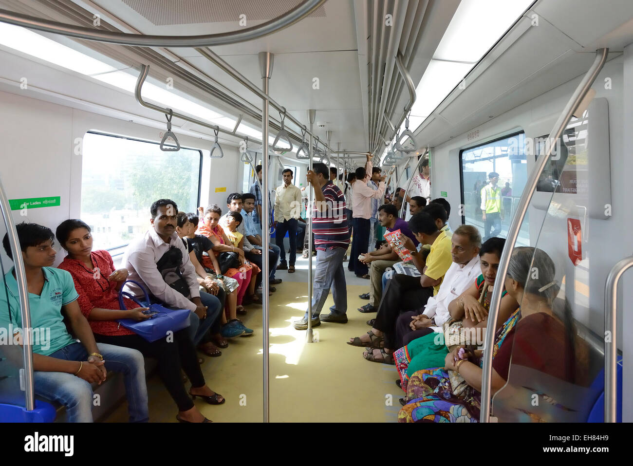 Bombay, India - June 22, 2014: People sitting inside Mumbai (Bombay) Metro at Ghatkopar Metro station going towards Versova Andh Stock Photo