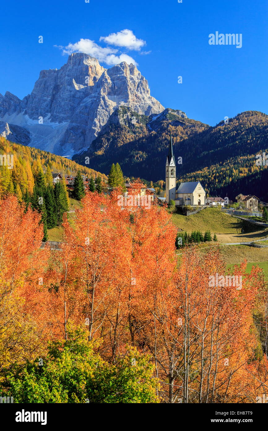 Red and orange trees in front of the tiny church of Selva di Cadore, with Mount Pelmo in the background, Veneto, Italy Stock Photo