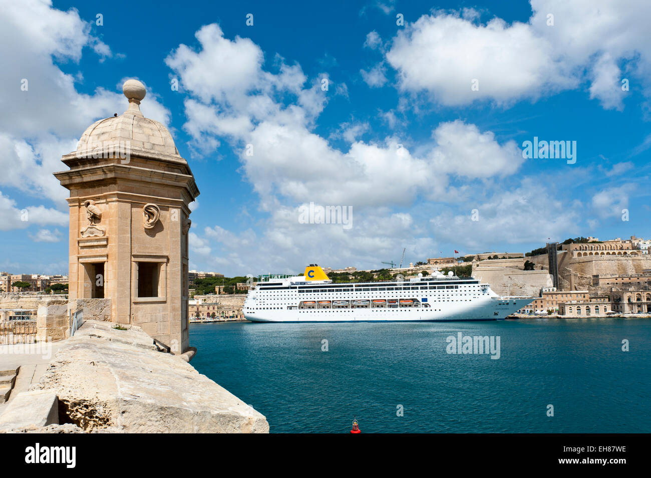 Lookout point, watch tower in Senglea, with a berthed cruise ship in the historic centre at Upper Barrakka Gardens at the back Stock Photo