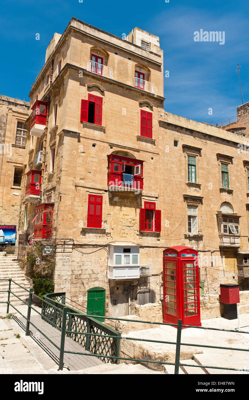Old residential house with red shutters, red telephone box, historic centre, Valletta, Malta Stock Photo