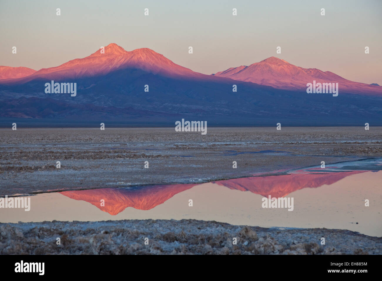 The profiles of two volcanos of the Cordillera de la Sal reflecting in a pool in the Desert of Atacama, Chile, South America Stock Photo