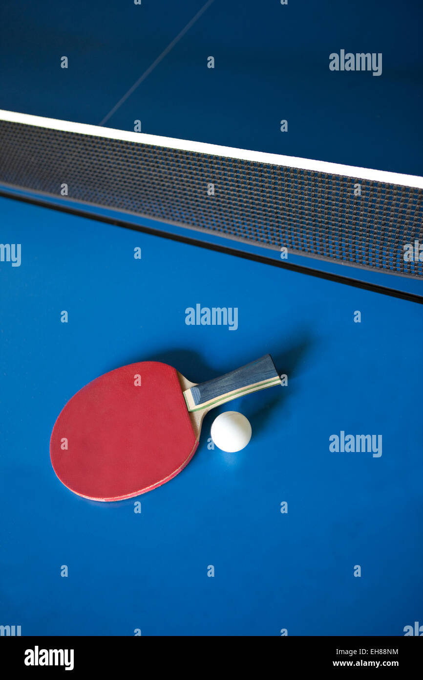 Racket and ball on a ping pong table Stock Photo