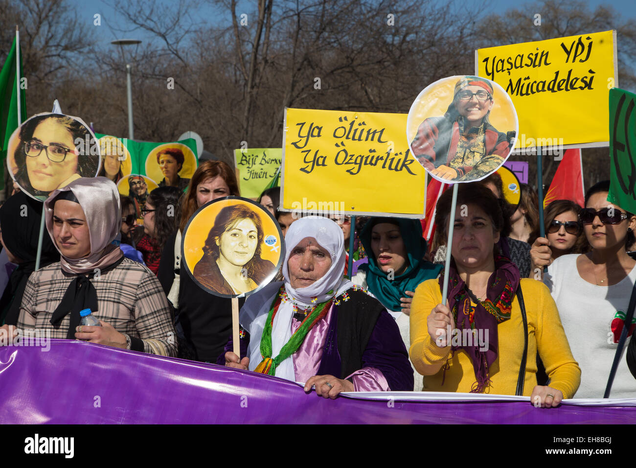 Women in a traditional Kurdish costume hold portraits of women murdered ...