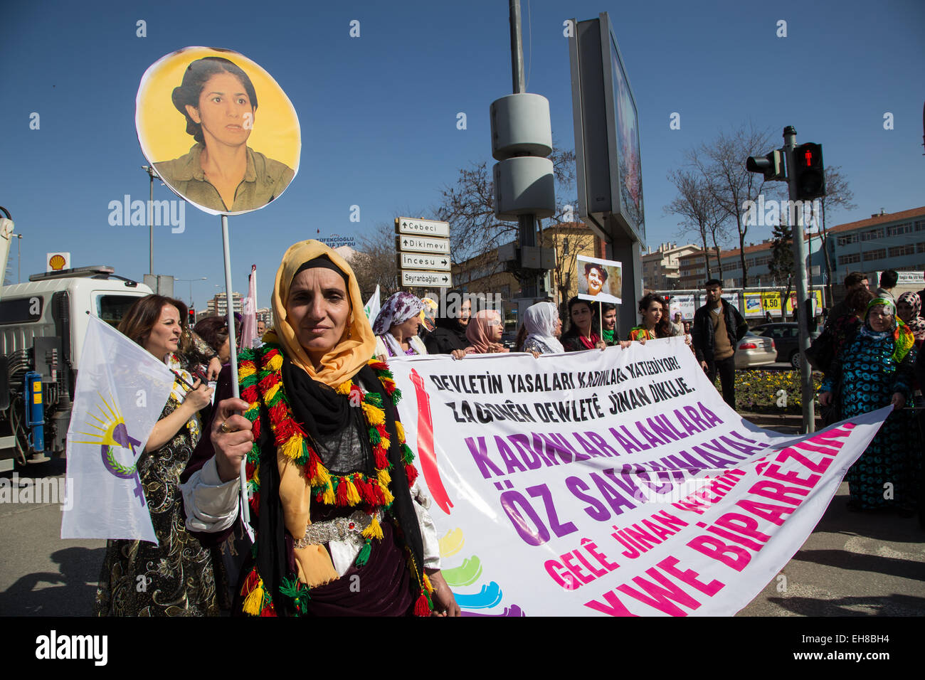 A woman in Kurdish traditional costume hold the portrait of a Kurdish ...