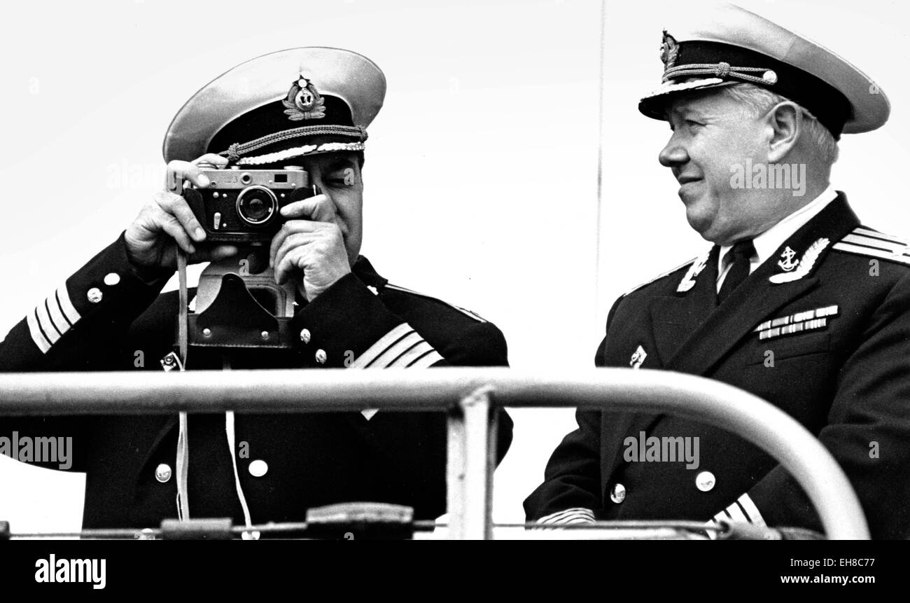 AJAXNETPHOTO -28TH MAY 1976 - PORTSMOUTH,ENGLAND. WATCHING US WATCHING THEM - AN OFFICER ON THE DECK OF THE SOVIET (USSR) MISSILE CRUISER OZBRATSOVY PHOTOGRAPHS THE ROYAL NAVAL WELCOME COMMITTEE WHEN THE SHIP MADE A GOODWILL VISIT TO THE NAVAL BASE. PHOTO:JONATHAN EASTLAND/AJAX ORIGINAL REF:091954 Stock Photo