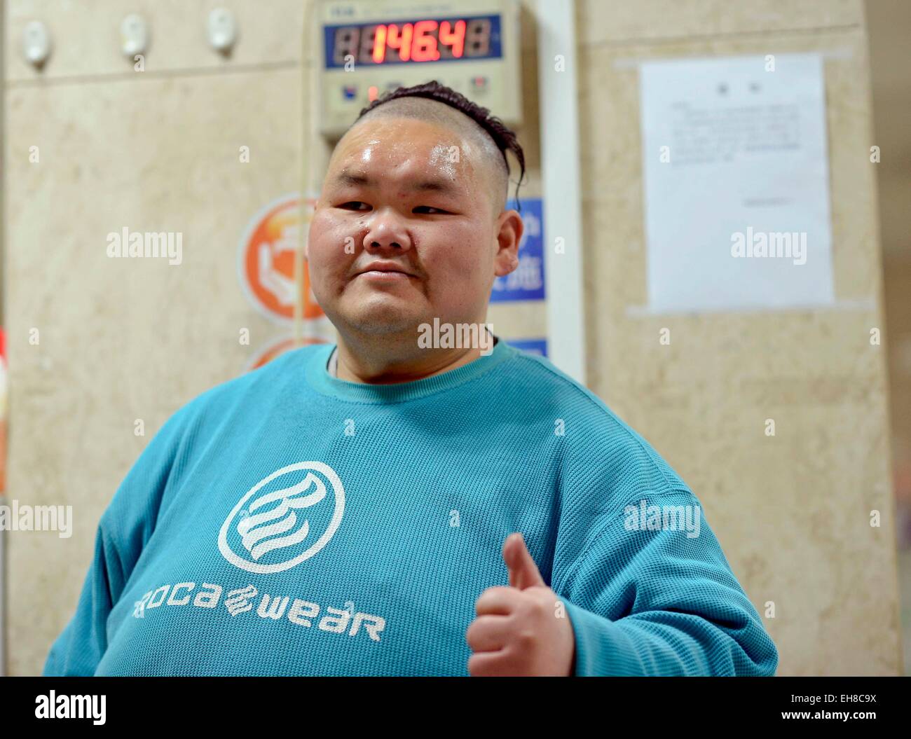 Chongqing. 9th Mar, 2015. Liang Yong weighs himself on a electronic