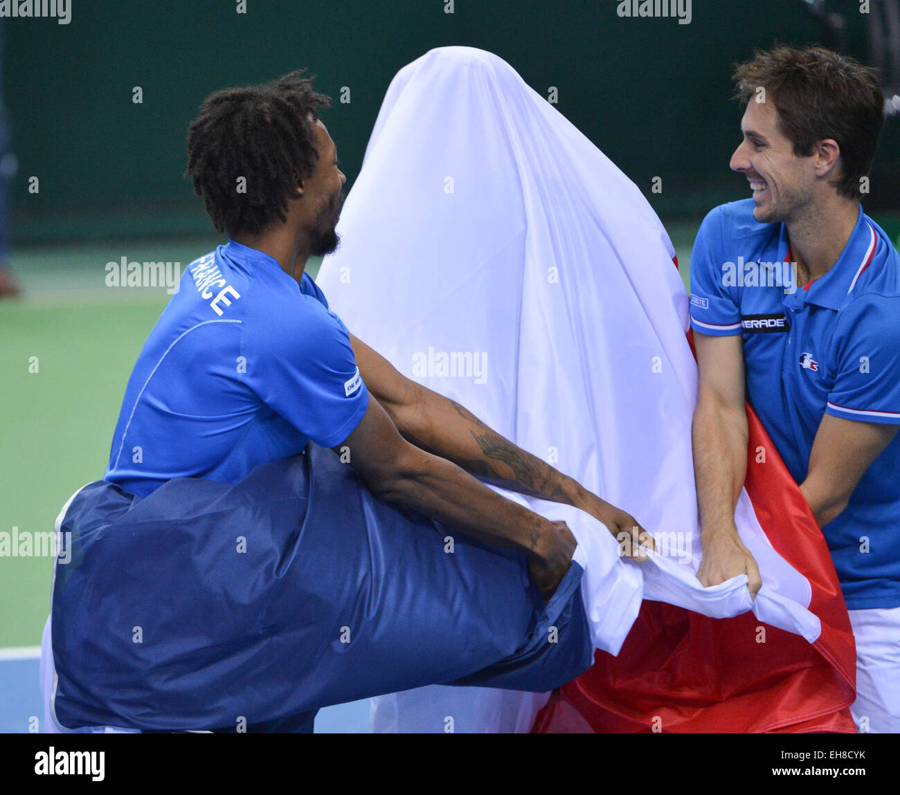 Frankfurt, Germany. 7th Mar, 2015. Edouard Roger-Vasselin (r) and Gael Monfils (l) of France cover their teammate Julien Benneteau in the French national flag during the men's first round of the Tennis Davis Cup match Germany vs France in Frankfurt, Germany, 7 March 2015. Photo: Arne Dedert/dpa/Alamy Live News Stock Photo