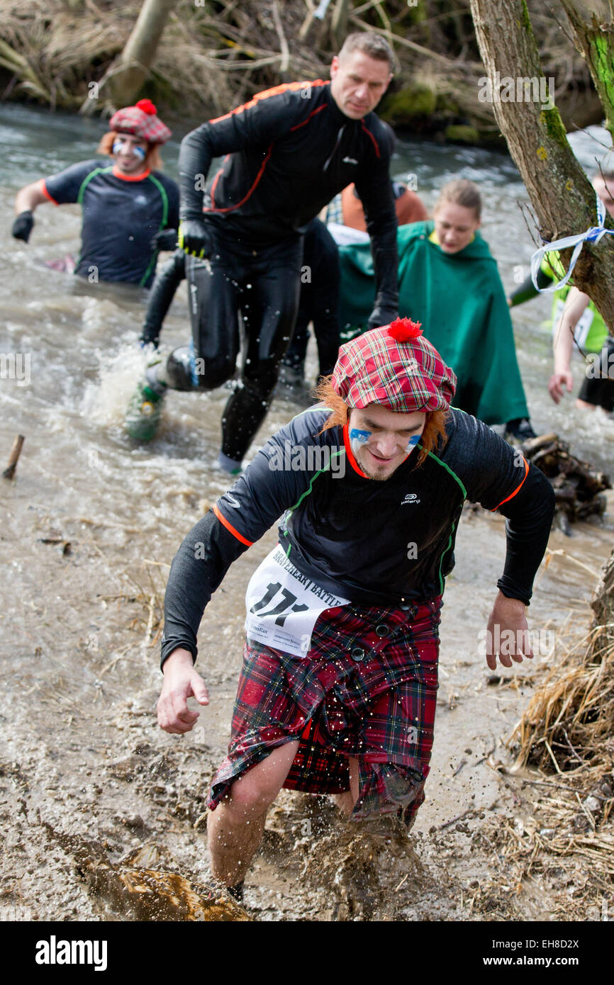 Participants struggle through a muddy river  during the extreme course event 'Braveheart-Battle' in Muennerstadt, Germany, 7 Mrach 2015. Around 2,500 runners have to over come 28 kilometres with 50 challanging obstacles wchih includes freezing cold water, mud pits and burning fire obstacles. The Braveheart-Battle course is considered one of the toughest in Europe. Photo:  Daniel Karmann/dpa Stock Photo