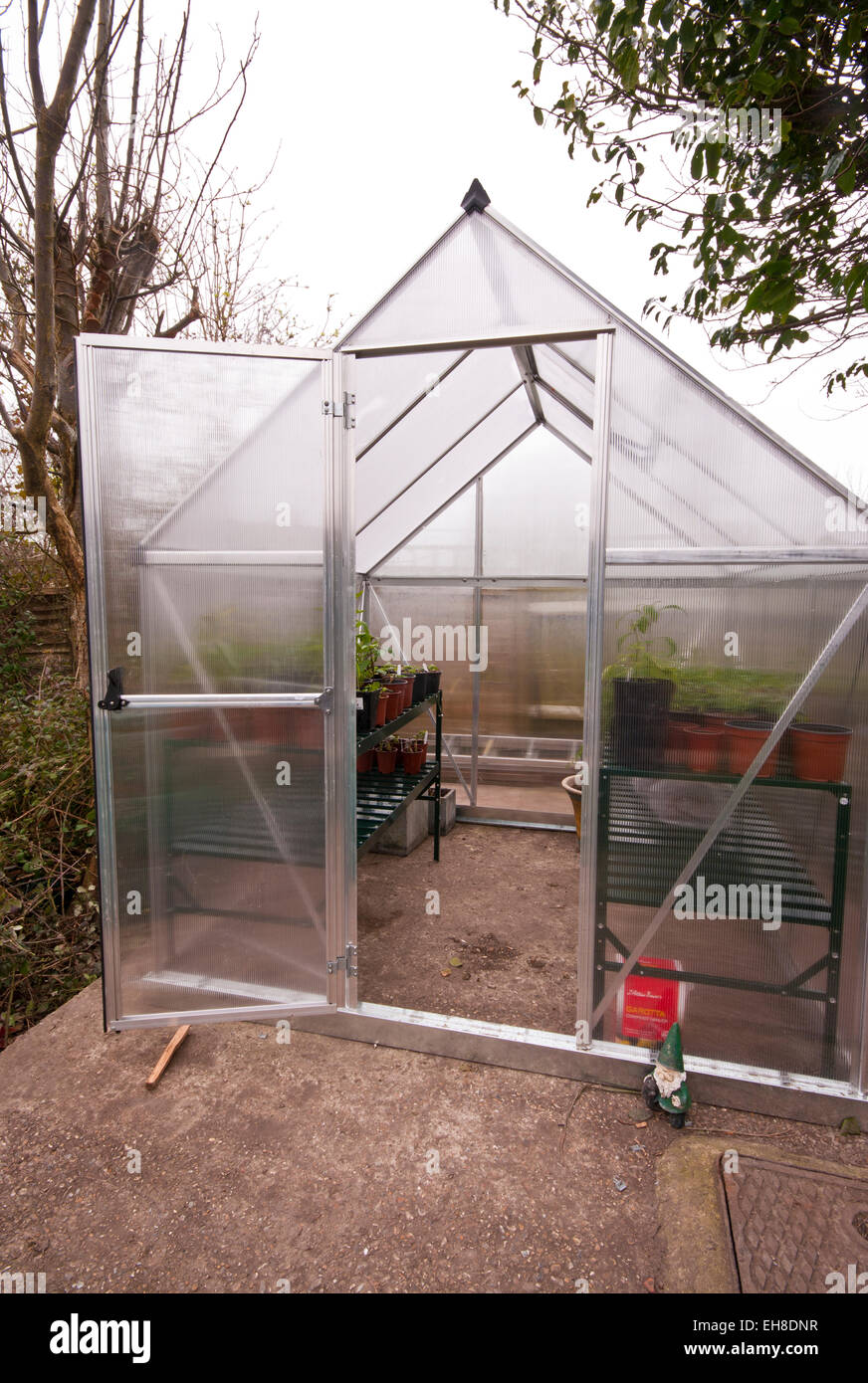 Front View Of A Polycarbonate Garden Greenhouse With The Door Open and