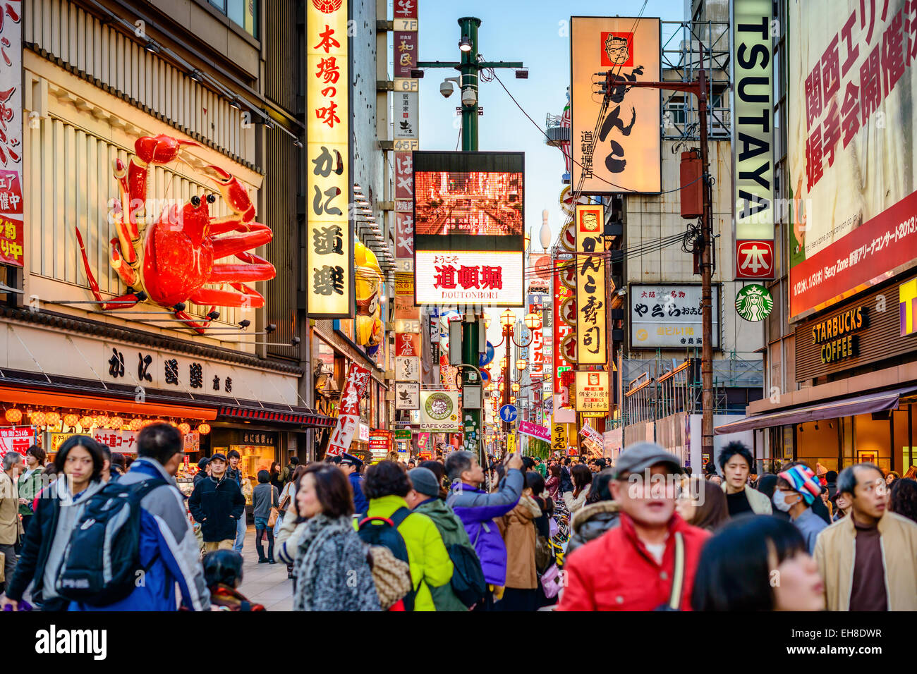 Crowds walk below the signs of Dotonbori District in Osaka, Japan. Stock Photo