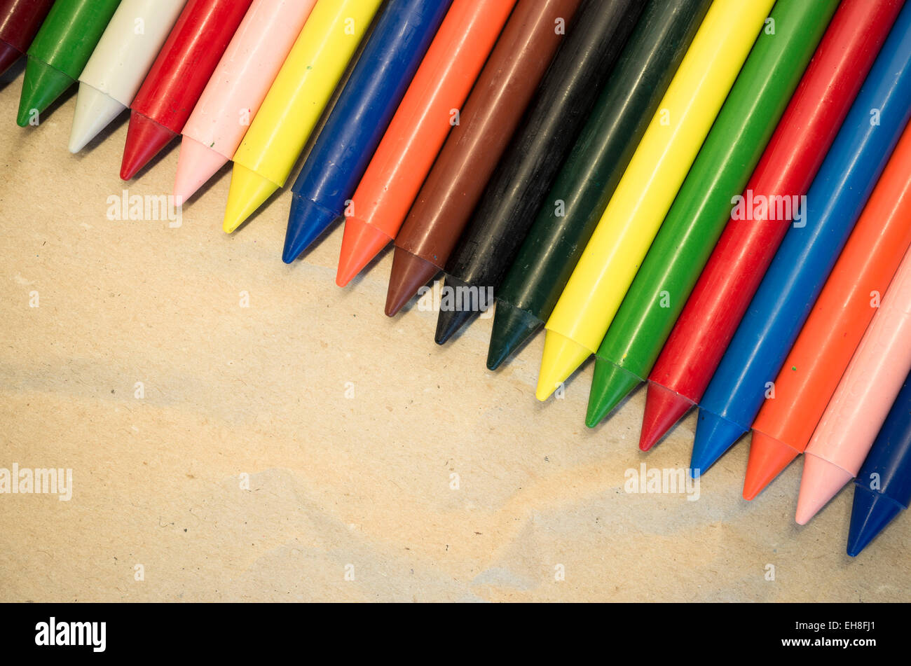 set of lined up colored wax crayons close up on a natural recycled ...