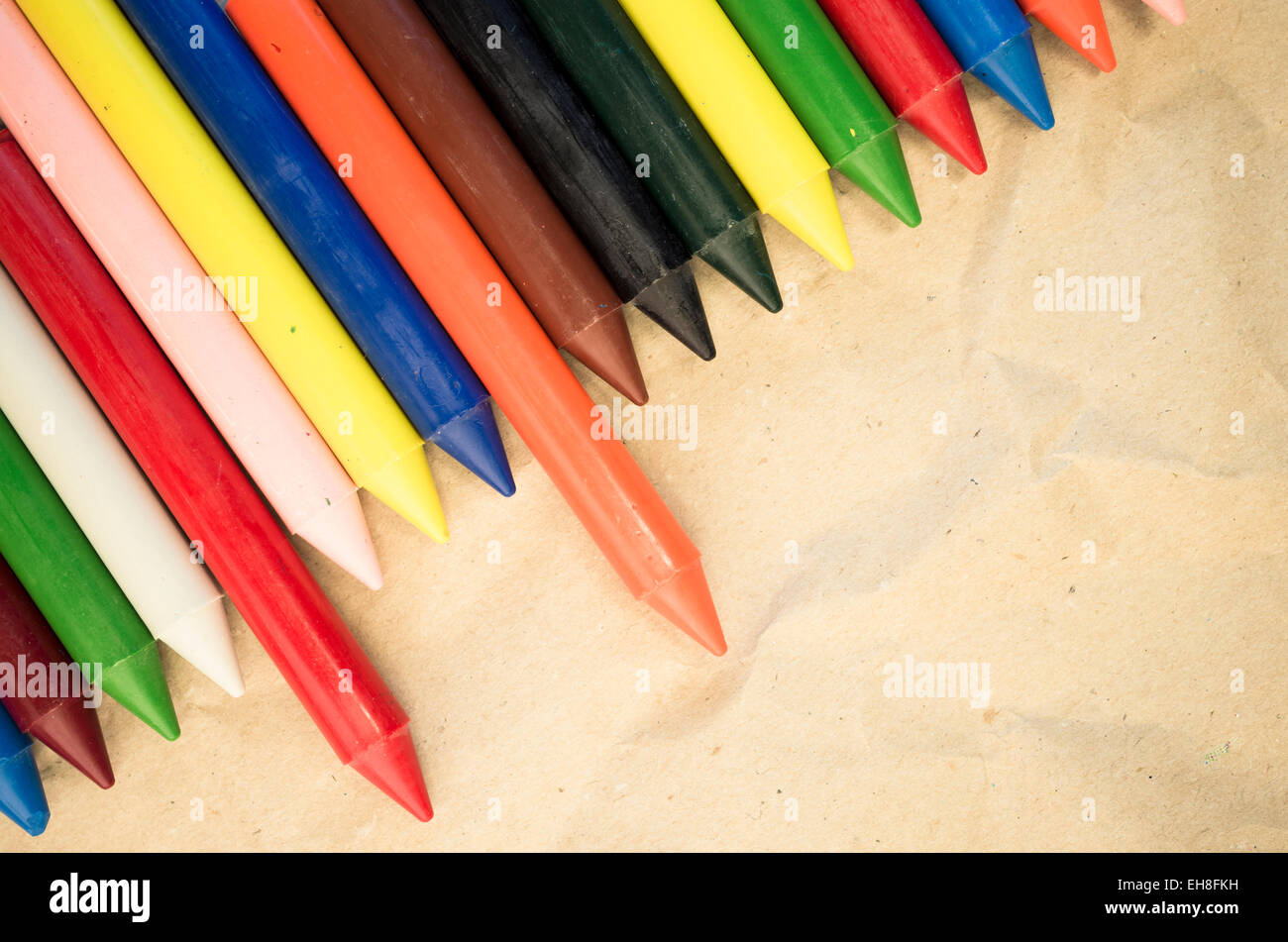 set of lined up colored wax crayons close up on a natural recycled ...