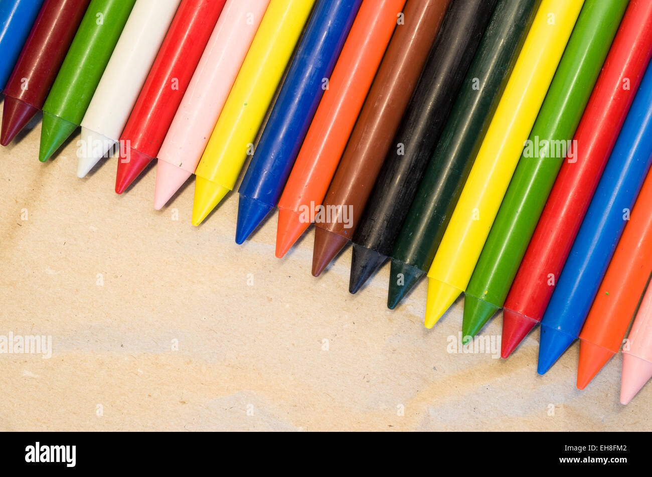 set of lined up colored wax crayons close up on a natural recycled ...