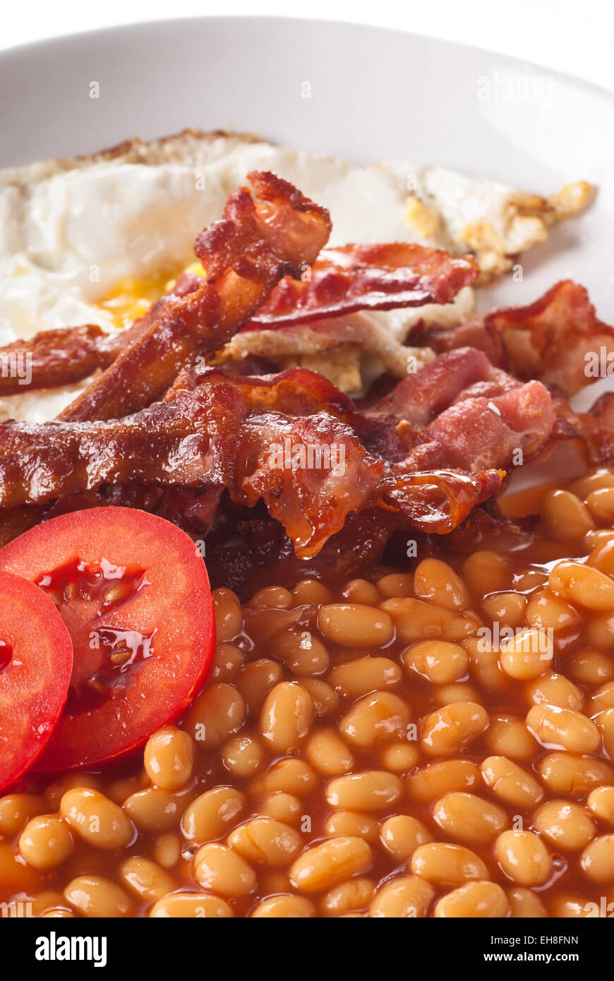 Bacon with baked beans and fried egg. Stock Photo