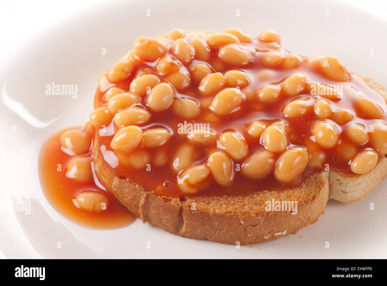 Baked beans on roasted bread. Stock Photo