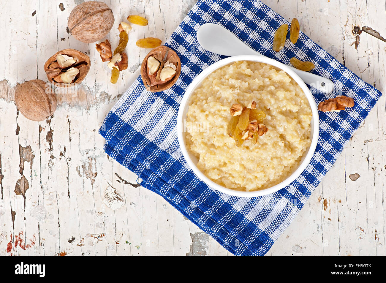 Porridge in a bowl with nuts and raisins Stock Photo