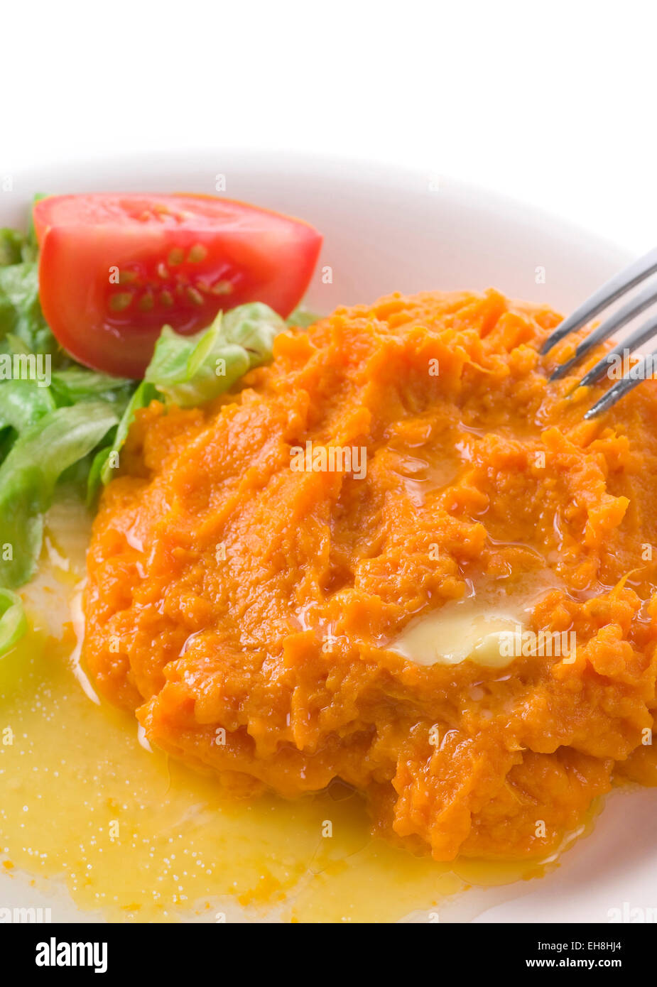 Mashed sweet potato with melted butter, salt and salad. Stock Photo