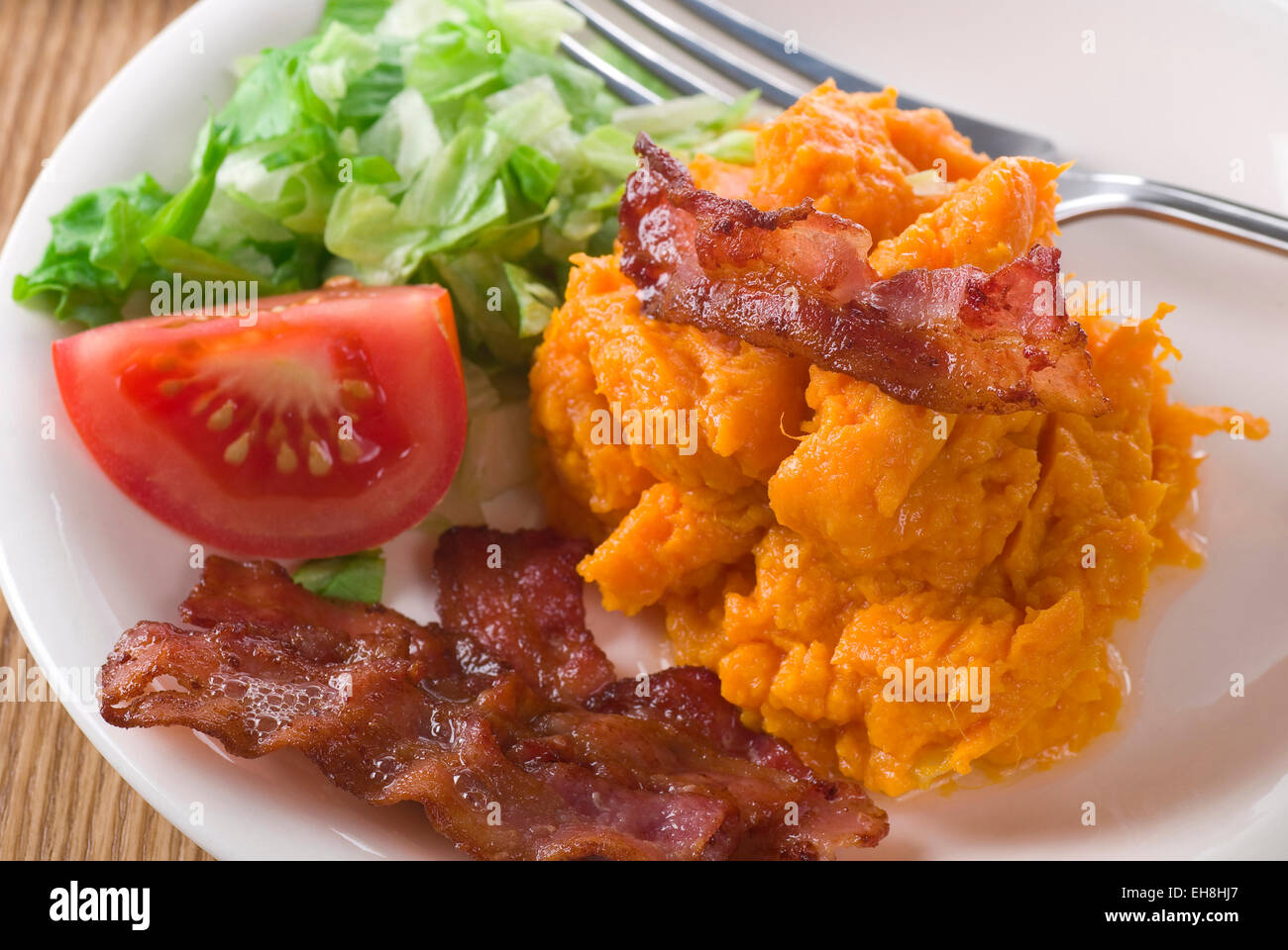 Bacon and mashed sweet potato with lettuce. Stock Photo