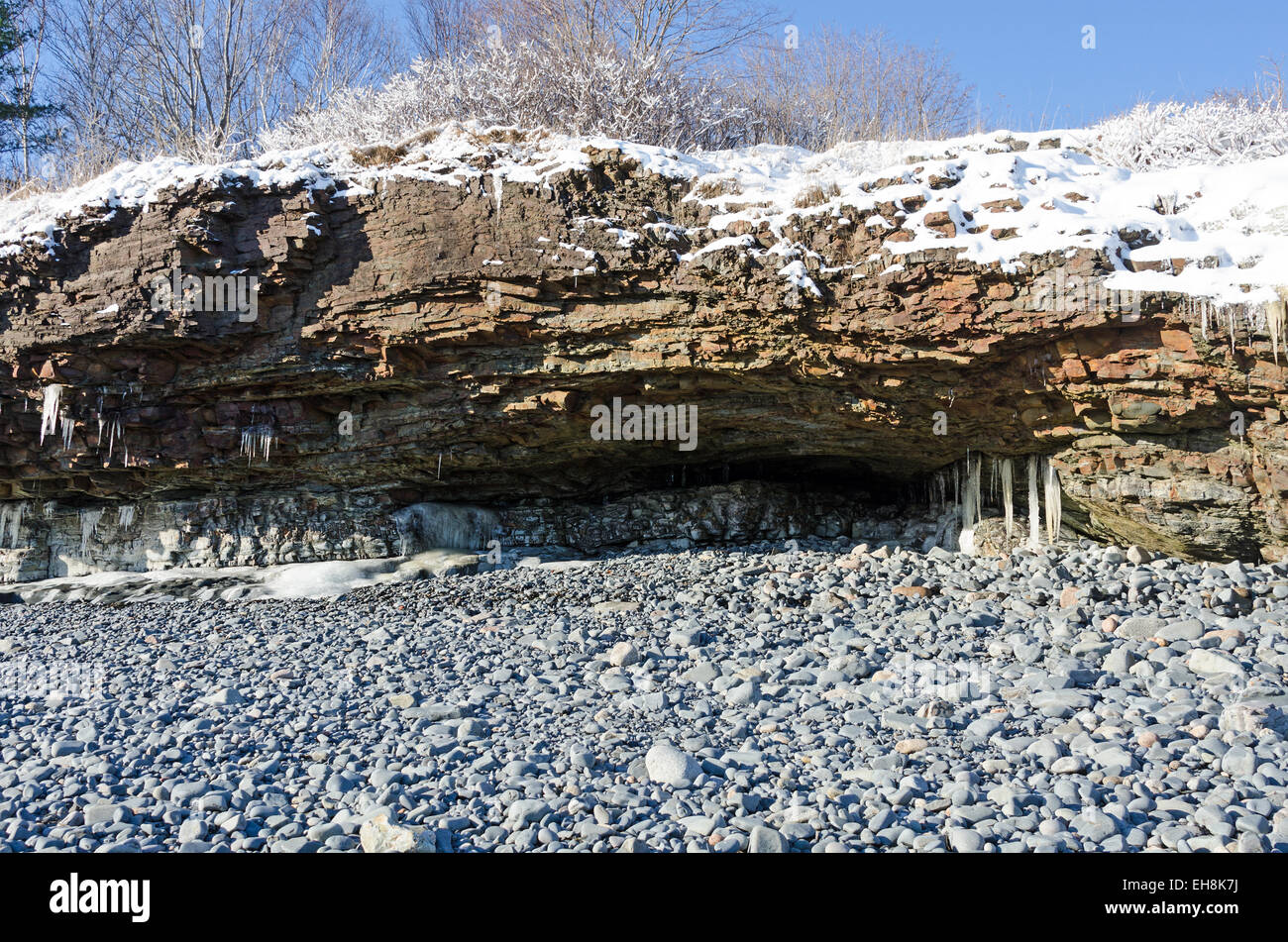 Low tide exposes a stone beach and a shallow sea cave, Bar Harbor