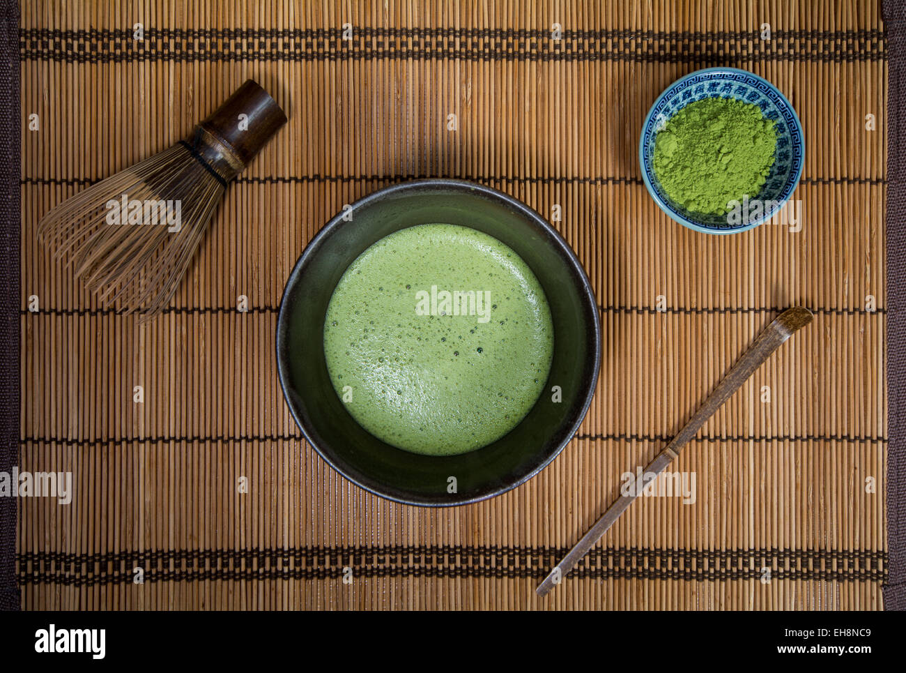 Bowl of Matcha with a Chasen a Chashaku and a bowl of Matcha powder on a place mat Stock Photo