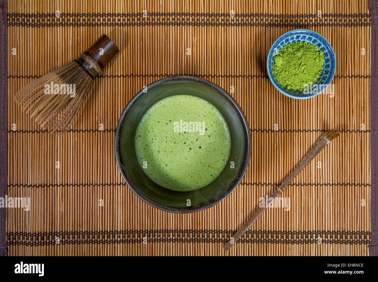 Bowl of Matcha with a Chasen a Chashaku and a bowl of Matcha powder on a place mat Stock Photo