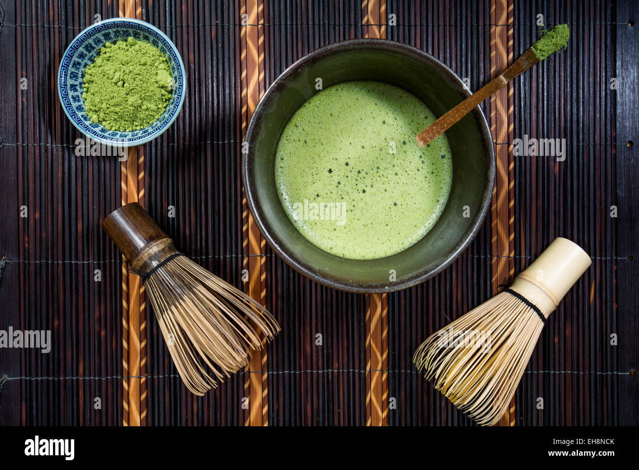 Bowl of Matcha with a Chasen a Chashaku and a bowl of Matcha powder on a place mat Stock Photo