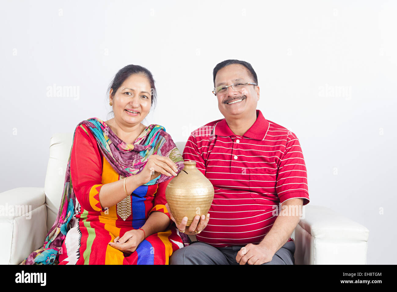 2 indian Seniors Married couples sitting sofa Piggy Bank Saving money ...