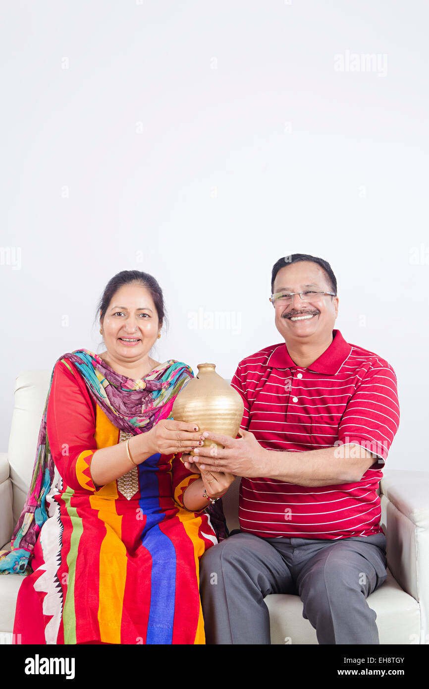 2 indian Seniors Married couples sitting sofa Piggy Bank Saving money ...